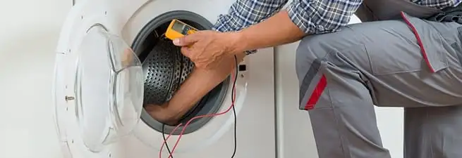 Dryer repair technician inspecting and repairing a clothes dryer in Hollywood, FL