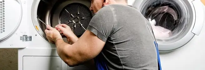 Dryer repair technician fixing a clothes dryer drum in Hollywood, FL