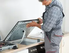 Appliance repair technician installing a built-in cooktop in Hollywood, FL