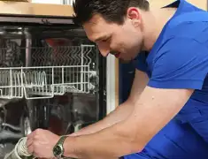 Dishwasher repair technician inspecting and servicing an open dishwasher in Hollywood, FL