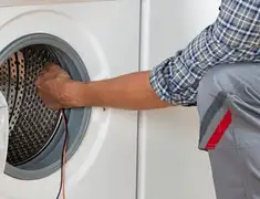 Dryer repair technician diagnosing and servicing a clothes dryer in Hollywood, FL