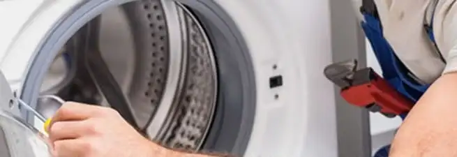Appliance technician repairing a clothes dryer drum and internal parts in Hollywood, FL