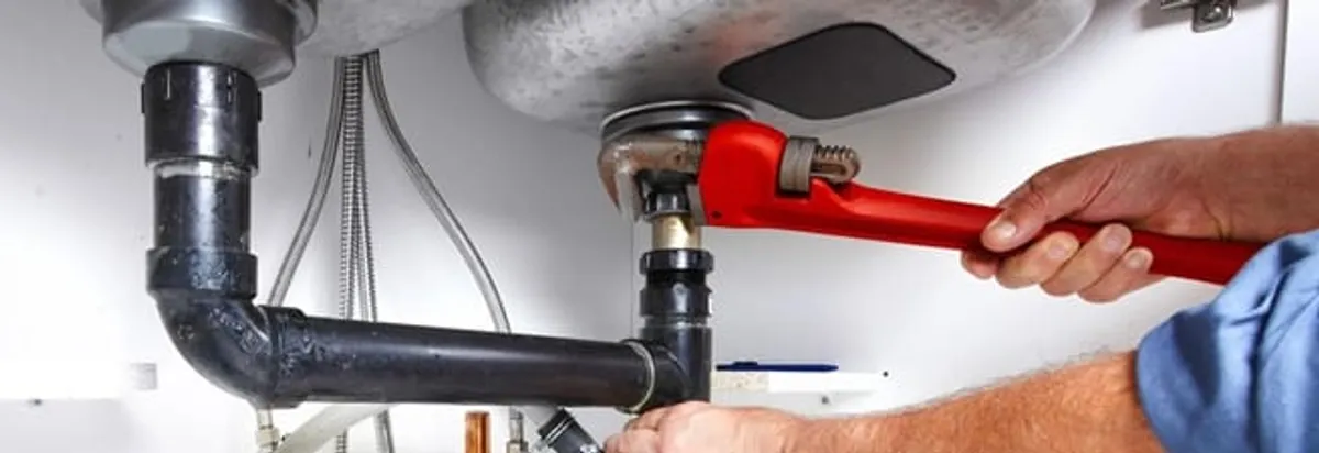 Garbage disposal repair technician tightening the sink drain and disposal connection in Hollywood, FL