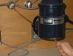 Garbage disposal repair technician tightening the mounting ring under a sink in Hollywood, FL