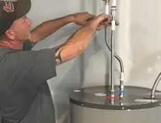 Water heater repair technician tightening supply line connections in Hollywood, FL